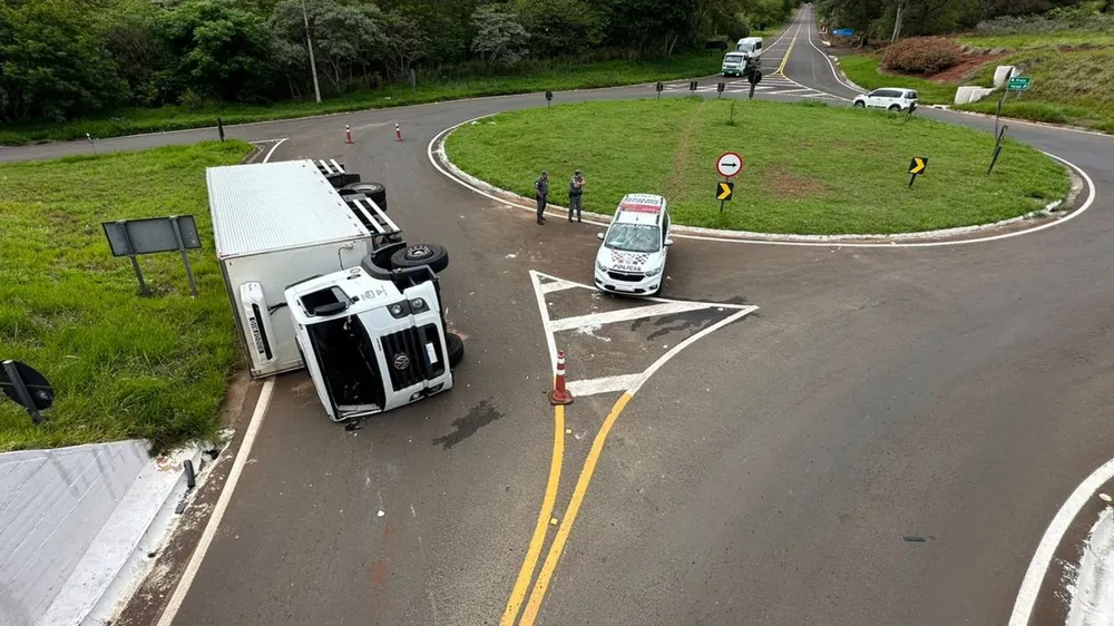 Caminhão tomba em rotatória na região passageiro ficou ferido